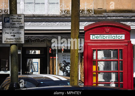 Traditionelle britische rote Telefonzelle auf einer öffentlichen Straße/Defibrillator umgewandelt. Montpellier, Cheltenham, Gloucestershire Stockfoto