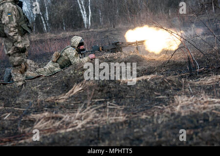 Eine ukrainische Soldaten mit der 1.Bataillon, 28 Mechanisierte Infanteriebrigade Brände eine modifizierte DSHsK Heavy Machine Gun die Vorauszahlung der Gefährte 1-28 Soldaten während einer Live-Fire Training übung in der yavoriv Combat Training Center auf dem internationalen Friedens und der Sicherheit, in der Nähe der Yavoriv, Ukraine, der am 16. März. Die live-fire Übung ist Teil eines Blockes der Anweisung von ukrainischen Combat Training Center Personal unterrichtet, die durch Mitglieder des Gemeinsamen multinationalen Ausbildung Group-Ukraine betreut werden. JMTG-U ist eine Koalition aus servicemembers aus Kanada, Dänemark, Litauen, Stockfoto