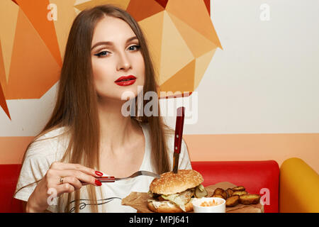 Lachende Frau Burger essen Stockfoto