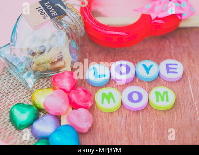 Liebe Mama mit bunten Alphabet Bausteine und ein rotes Herz auf Holzbrett und Sack isoliert - Muttertag geschrieben Stockfoto