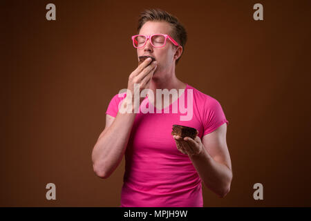 Jungen gutaussehenden Mann mit rosa Hemd und Brille gegen Bro Stockfoto