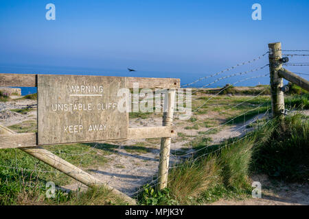 Eine hölzerne Warnschild Beratung von einer instabilen Klippe entfernt an der Jurassic Coast in Dorset, England, UK halten Stockfoto