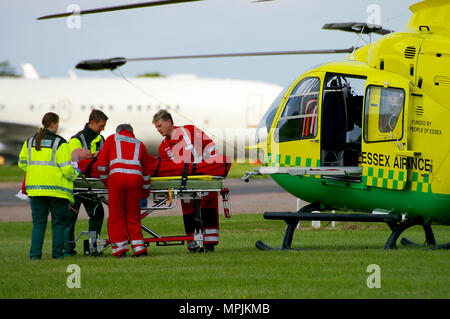 Essex Air Ambulance Hubschrauber Eurocopter EC 135 G-SSXX mit Sanitäter und Notarzt Crew, die sich mit einem Transfer auf einem Trolley Stockfoto