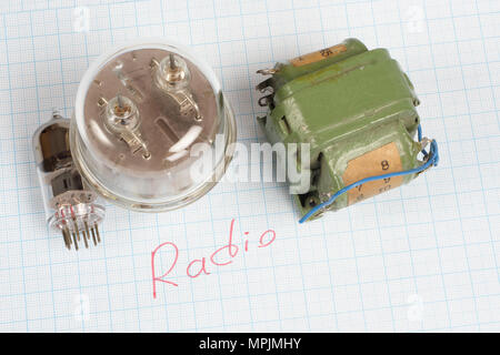 Alte Röhre (Electron Tube) und des Transformators auf Millimeterpapier Hintergrund Stockfoto