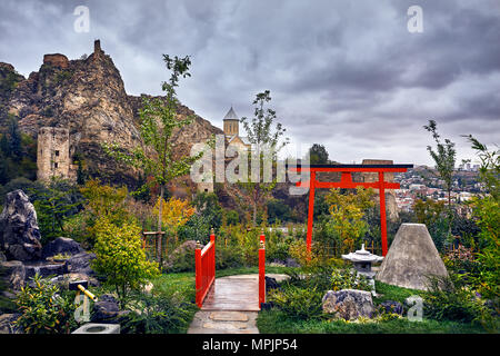 Japanischen Garten und das alte Schloss Narikala an bedeckt bewölkter Himmel im Botanischen Garten von Tiflis, Georgien Stockfoto