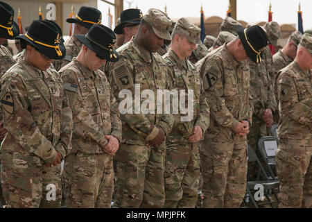 (Von links nach rechts) den Befehl Sgt. Maj. Jill Crosby, Senior Soldaten Advisor der 1 Kavallerie Division Sustainment Brigade, Oberst Christopher Colavita, Kommandant der 1. Cav. Div. Sustainment Brigade; Command Sgt. Maj. Perry Williamson, Senior Advisor Soldaten des 401St Army Field Support Brigade, Oberst Aaron Stanek, Kommandant der 401St AFSB; und 1. Kavallerie Division kommandierenden General Generalmajor John Thomson Bogen ihre Köpfe im Gebet während der anrufung der bei der Übertragung der Autorität Zeremonie am Lager Buehring, Kuwait, den 12. März. Nach neun Monaten erreichte der 3. Gepanzerten Brigade Combat Team, 1 Ar Stockfoto