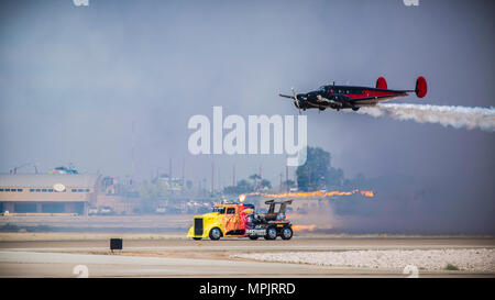 Der Shockwave Jet Truck führt während der Yuma Airshow 2017 auf der MCAS Yuma, Arizona, am 18. März 2017 zusammen mit Matt Younkins Twin Beech 18 einen Hochgeschwindigkeitspass auf der Fluglinie durch. Der Shockwave Jet Truck wird von einem Jet-Triebwerk angetrieben, das einen hohen Schub erzeugt und eine schnelle Beschleunigung ermöglicht, während die Twin Beech 18 ein zweimotoriges Propellerflugzeug ist. Bei der Demonstration werden die Koordination von Fahrzeugen und Flugzeugen, das präzise Timing und die Stuntleistung für das Publikum der öffentlichen und militärischen Luftfahrt vorgestellt. Stockfoto