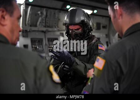 Kapitän Jason Carroll, 15 Airlift Squadron airdrop Fluglehrer vor einem Flug nach Norden Auxiliary Airfield in Nord-, Süd Carolina, 15. März 2017 In-flight Training mit aircrew Augen- und Atemschutz System (AERPS) Geräten auszuführen. Der Flug war das erste Mal in mehr als 10 Jahren, in denen Piloten AERPS Ausrüstung trug. AERPS Ausrüstung besteht aus einem Gummi Maske, mehrere Schichten von Stiefel und Handschuhe, Fan Filter System und ein Audio- und Lautsprechersystem. (U.S. Air Force Foto/Airman 1st Class Megan Munoz) Stockfoto