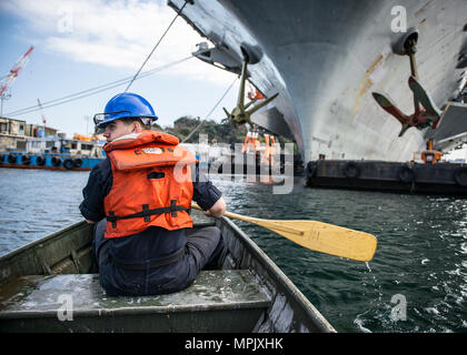 Der Luftfahrt Bootsmann Mate (Handling) Airman Dalen Evans, von Pensacola, Florida, Manöver eine kleine Aluminium Profil gegenüber der Marine nur Vorwärts - bereitgestellt Flugzeugträger USS Ronald Reagan (CVN 76). Evans verwendet, um das Boot zu Transit auf der Backbordseite des Schiffes Restaurierungsarbeiten an den Anker zu führen. Ronald Reagan, das Flaggschiff der Carrier Strike Group 5, bietet eine Bekämpfung bereit, Kraft, schützt und verteidigt die kollektive maritime Interessen seiner Verbündeten und Partnern in der Indo-Asia-Pazifik-Region. (U.S. Marine Foto von Mass Communication Specialist Seaman Tyler D. John/Freigegeben) Stockfoto