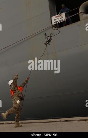 1. Sgt. Adolph Romero, der Transport Supervisor für die 936Th Expeditionary Terminal in Betrieb Element und Eingeborene von Dover, Fla., hilft, die große, mittlere Geschwindigkeit sicher, Roll on Roll off Fahrzeug cargo ship USNS Brittin (T-AKR-305), zum Pier am Hafen von Shuaiba, Kuwait, den 12. März. Die etoe im September 2015 für den alleinigen Zweck, damit die Armee terminal Betrieb im Theater zu führen. Stockfoto