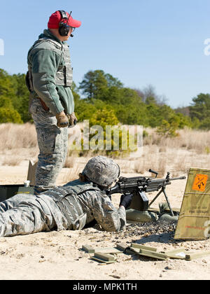 Senior Airman Jeffrey Burton, 436Th Security Forces Squadron Combat Arms Instructor, überprüft den Streik Muster der M-249 Light Machine Gun abgefeuert durch Airman 1st Class Annamae Prentiss, 436Th SFS Response Force Mitglied, 9. März 2017, In der Reihe 7 am Joint Base Mc Guire-Dix - Lakehurst, N.J. Prentiss war einer von vier 436Th SFS Mitglieder nach Dover Air Force Base, Del zugeordnet, die auf der M-249 von Feuern auf stillgelegten Tanks in verschiedenen Entfernungen, die zwischen 200 bis 1.200 Meter ausgebildet. (U.S. Air Force Foto von Roland Balik) Stockfoto