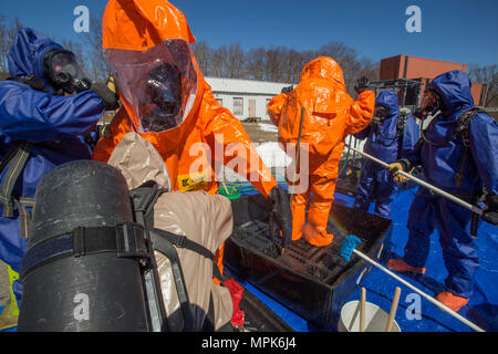 Strike Team Mitglieder Sgt. Joe Bercovic, zweiter von links, und die Mitarbeiter der Sgt. Nicky Lam, Center, beide mit 21 Waffen der New Jersey National Guard von Mass Destruction-Civil Support Team, werden durch Picatinny Arsenal Feuerwehrmänner während einer Übung mit dem Picatinny Arsenal Feuerwehr am New Jersey Homeland Defense Homeland Security Center am Picatinny Arsenal, N. J., März 23, 2017 dekontaminiert werden. Das 21 WMD-CST ist eine gemeinsame Einheit aus New Jersey National Guard Soldaten und Piloten, deren Aufgabe es ist, die zivilen Autoritäten durch die Identifizierung von chemischen, biologischen, radiologischen, Stockfoto