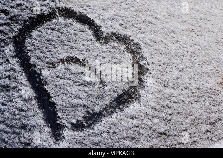 Eine Zeichnung in der Form eines Herzens auf den gefallenen Schnee auf dem Auto Glas Stockfoto