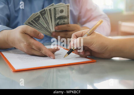 Mann mit Batch von Hundert-euro-Scheine. In der Nähe von Mann unterzeichnen Vertrag machen einen Deal, business Vertragsdaten. Stockfoto