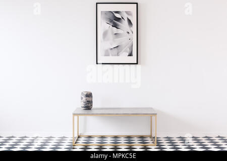 Minimalistische Schwarz-Weiß-Wohnung innen für einen Künstler mit einem luxuriösen goldenen Bank und ein gerahmtes Bild auf eine leere Wand Stockfoto