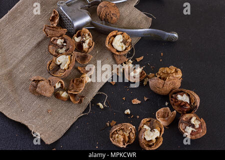 Walnüsse und einen Nussknacker auf eine Tabelle mit Sackleinen abgedeckt Stockfoto