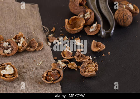 Walnüsse und einen Nussknacker auf eine Tabelle mit Sackleinen abgedeckt Stockfoto