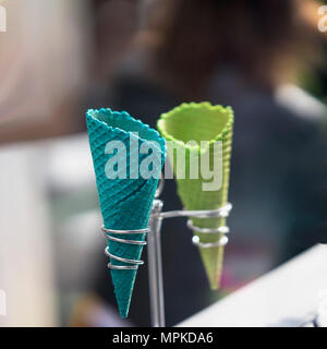 Zwei leere helle Wafer süße Cornets für Speiseeis auf realen verschwommenen Hintergrund. Selektive konzentrieren. Kopieren Sie Platz. Realen Szene im Store. Konzept der Sommer, Süßigkeiten Stockfoto