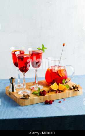 Frische Sommer rote Sangria aus reifen Früchten und Beeren sowie Wein auf dem Tisch in Gläsern und einer Karaffe. Gewürzen und Minze Stockfoto
