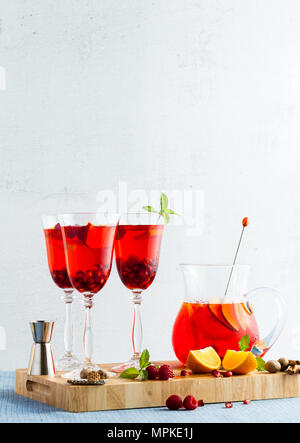 Frische Sommer rote Sangria aus reifen Früchten und Beeren sowie Wein auf dem Tisch in Gläsern und einer Karaffe. Gewürzen und Minze Stockfoto