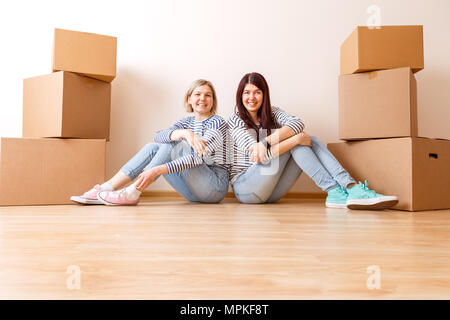 Foto von zwei Mädchen sitzen auf dem Boden der Kartons Stockfoto
