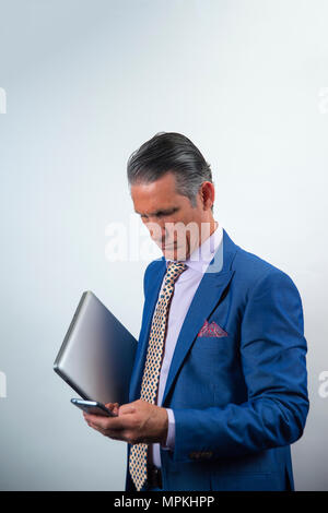 Elegante Executive mit Laptop und Mobiltelefon Stockfoto