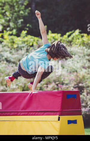 Mädchen üben (Üben) Gymnastik im Freien auf Voltigieren Pferd Stockfoto