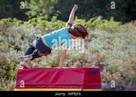 Mädchen üben (Üben) Gymnastik im Freien auf Voltigieren Pferd Stockfoto