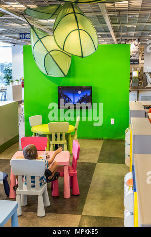 Kind beim Fernsehen im Restaurant eines Ikea-Geschäfts in den USA Stockfoto