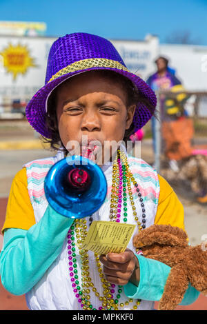 Kleines schwarzes männliches Kind, das für Mardi Gras gekleidet ist, mit einem lila Hut und einem Plastikhorn bei der Mardi Gras Parade im Zentrum von Gulfport, Mississippi Stockfoto