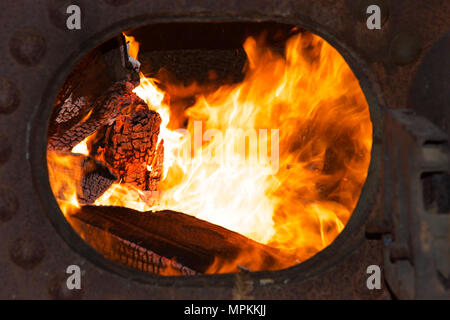 Feuer in einem Metall Dampfkessel Energie Sägewerk Ausrüstung zu produzieren. Holzabfälle aus der Mühle bietet eine Quelle von Brennstoff für das Feuern t Stockfoto