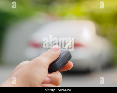 Frauen Hand drückt auf der Fernbedienung Auto Alarmanlagen Stockfoto