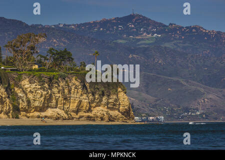 Abgeschiedene Dume Cove Beach und hohen Klippen mit Santa Monica Mountains im Hintergrund, Malibu, Kalifornien Stockfoto