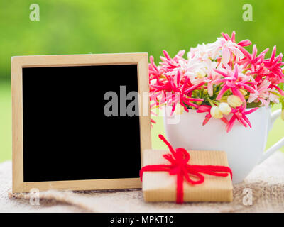 Plakat mock up Vorlage mit Blumenstrauß, Marshmallow in der Form von Herzen und Geschenk über grüner Hintergrund Stockfoto