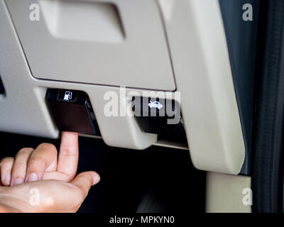 Hand mit einem Schalter zum Öffnen der Tank im Fahrzeug Stockfoto