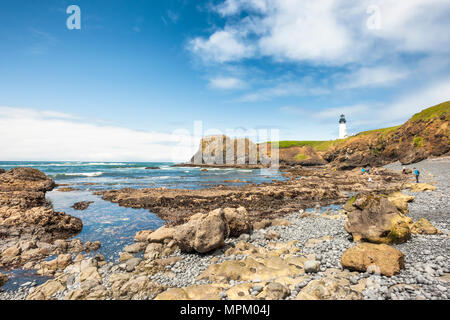 Newport, Oregon, USA - 21. März 2017: Menschen entdecken Sie die Gezeiten Felsen, die tidepools voll von Sea Life als Yaquina Head Lighthouse halten hohen Tribünen Stockfoto