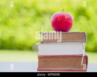 Welttag des Buches Konzept. Red Apple und setzen auf Stapel alte Bücher Stockfoto