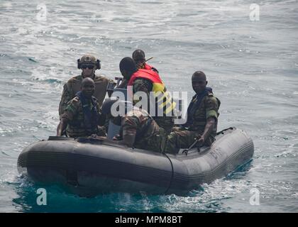 170325-N-GP 524-394 Cotonou, Benin (25. März 2017) der U.S. Coast Guard Maritime Durchsetzung Specialist 3. Klasse Nathan Emborski mans eine starre Hülle Schlauchboot mit Benin Matrosen nach Bewertung ein Besuch, Board, Durchsuchung und Beschlagnahme bohren während der Übung Obangame Express, 25. März 2017. Obangame Express, durch US Africa Command gefördert, ist entworfen, um die regionale Zusammenarbeit, den maritimen Bereich Sensibilisierung, Information-sharing-Praktiken zu verbessern, und Taktische verbot Expertise der kollektiven Fähigkeiten des Golfs von Guinea und an der westafrikanischen Ländern zu verbessern Meer-basierte illegalen Aktivität zu begegnen. (U Stockfoto