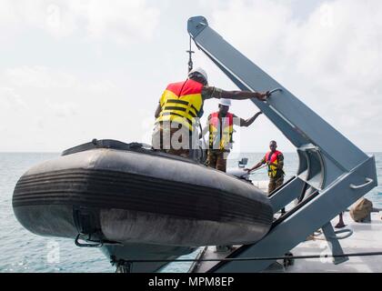 170325-N-GP 524-416 Cotonou, Benin (25. März 2017) Benin Matrosen Wiederherstellen eines starren Hülle Schlauchboot nach einem Besuch, Board, Durchsuchung und Beschlagnahme bohren während der Übung Obangame Express, 25. März 2017. Obangame Express, durch US Africa Command gefördert, ist entworfen, um die regionale Zusammenarbeit, den maritimen Bereich Sensibilisierung, Information-sharing-Praktiken zu verbessern, und Taktische verbot Expertise der kollektiven Fähigkeiten des Golfs von Guinea und an der westafrikanischen Ländern zu verbessern Meer-basierte illegalen Aktivität zu begegnen. (U.S. Marine Foto von Mass Communication Specialist 2. Klasse Bill Dodge) Stockfoto