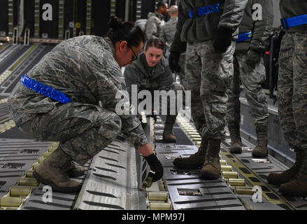 Staff Sgt. Jacquelyn Alvarez, Antenne Anschluss 721st Squadron NCO verantwortlich für die Einheit Learning Center, hilft ein Student flip Walzen über innerhalb eines C-17 Globemaster III vor dem Laden Ladung auf das Flugzeug auf der Air Base Ramstein, Deutschland, 21. März 2017. Die Einheit Learning Center bietet neue Flieger die Ausbildung für Sie Ihre Upgrade Training für den Personenverkehr, Luftfracht, und Ramp Services. (U.S. Air Force Foto von älteren Flieger Tryphäna Mayhugh) Stockfoto