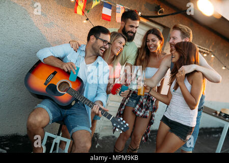 Freunde Spaß und trinken Cocktails Außenpool auf der Dachterrasse zusammen erhalten Stockfoto
