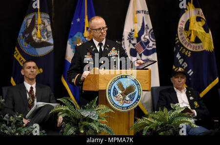 Oberst Damon Gluckern, Leiter des militärischen Unterstützung, Arkansas National Guard, hält die Medaillen von seinem Vater und U.S. Navy Veteran, Petty Officer Larry N. Gluckern, wie er Adressen ein Publikum von Veteranen während des 2. jährlichen 50-Jahr-Feier zur Erinnerung an die Rückkehr von Vietnam Veteranen aus dem Krieg am 28. März, am Ft. Wurzeln VA Medical Center in North Little Rock, Arche. Larry N. Cluck diente in der US Navy von 1966-1970. Gluckern, zwei Kreuzfahrten nach Vietnam an Bord der U.S.S. Konstellation. Er war auch ein Mitglied der Besatzung auf der E-2 ein Hawkeye Radar Ebene. Stockfoto