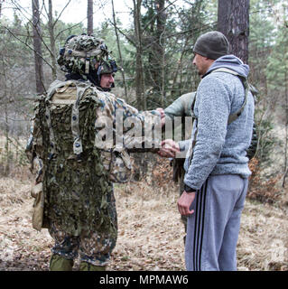 Soldaten aus dem ersten Bataillon, 10 Special Forces Group (Airborne) und mazedonischen Special Operation Forces Hände schütteln mit 1 Lettische Brigade Soldaten während einer Mission auf der Gemeinsamen multinationalen Readiness Center in Hohenfels, Deutschland, 20. März 2017. Diese Maßnahme war Teil der Übung Allied Geist VI, integriert die multinationale Special Operation Forces und konventionelle Streitkräfte Ausbildung auf kombinierte Interoperabilität und gegenseitige Abhängigkeit. (U.S. Armee Foto von Sgt. Nelson Robles, SOCEUR Public Affairs) Stockfoto