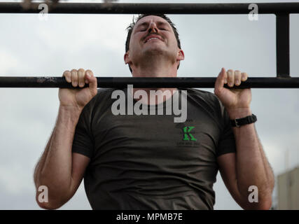 Ein US-Mitglied beteiligt sich an der Pull-up-Teil der Gemeinsamen Krieger Wettbewerb (JWC) auf Lager Lemonnier, Dschibuti, 25. März 2017. Die Teilnehmer des JWC testen sie sich physisch an verschiedenen Veranstaltungen, darunter 20 zeitgesteuerte Pull-ups. (U.S. Air National Guard Foto: Staff Sgt. Christian Jadot) Stockfoto