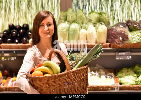 Junge hübsche Frau Einkaufen für frische, gesunde Lebensmittel im Supermarkt Stockfoto