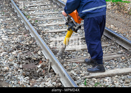 Anschluss Arbeiter führen Sie Wartungsarbeiten auf Eisenbahnschienen mit vertikalen Schwingungen. Stockfoto