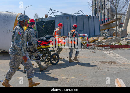 Us Air Force Senior Airman Johannes Childree, ein Arzt aus Die 116 medizinische Gruppe, Abteilung 1, 116. Air Control Wing, Georgia Air National Guard, Teams mit Soldaten aus dem Alabama National Guard bei der Suche und Gewinnung der Übung, die erforderlich ist, um sie einem verletzten Opfer zu retten, indem ein Mannequin gespielt, von einem Mann - Bohrung nach einem simulierten Hurrikan Szene im Guardian Zentrum in Perry, Ga, 29. März 2017 Während der chemischen, biologischen, radiologischen, nuklearen und explosiven Enhanced Response Force Paket Teil der Übung. Wachsam Guard 2017 Georgien ist eine gemeinsame regionale Schulungen ex Stockfoto