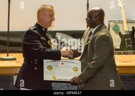 Oberst Peter Buck präsentiert der Congressional Gold Medal Zertifikat der Anerkennung für die pensionierten Sgt. Maj. Julius Jameson an Bord der Marine Corps Air Station Beaufort, am 25. März. Jameson akzeptiert die Medaille im Namen der späten Willis Jameson, eine Montford Point Marine. Der Congressional Gold Medal ist eine der höchsten Auszeichnungen in Anbetracht der Zivilbevölkerung in den USA Geld ist der kommandierende Offizier der WAB Beaufort. Stockfoto