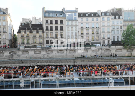 Touristenboot mit Menschen Touristen sitzen auf dem Deck, die eine Reihe von terrassenförmig angelegten Gebäude und Quai entlang der Seine in Paris Frankreich EU KATHY DEWITT Stockfoto