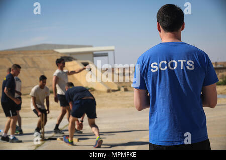 Ein britischer Soldat im Einsatz in der Unterstützung von Combined Joint Task Force - inhärenten lösen und die Highlanders, 4.Bataillon, das königliche Regiment von Schottland (4 Scots) Uhren eine Partie Kricket gespielt wird team Kameradschaft und die Moral im Al Asad Air Base, Irak, 26. März 2017 zu bauen. CJTF-OIR ist die globale Koalition zu besiegen ISIS im Irak und in Syrien. (U.S. Armee Foto von Sgt. Lisa Soja) Stockfoto